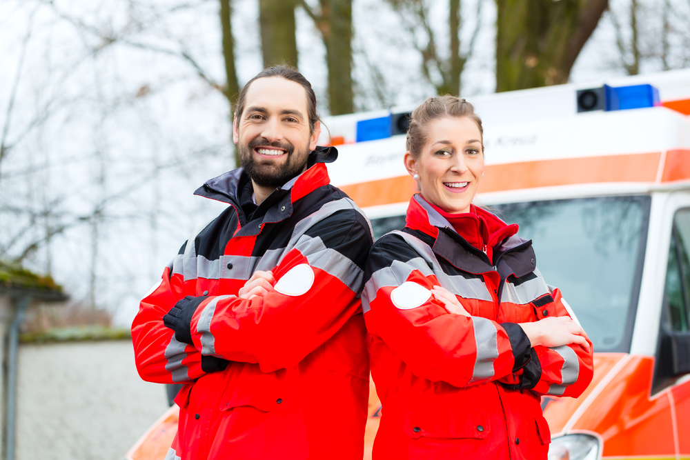 Emergency doctor and nurse standing in front of ambulance car